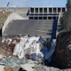 A small flow of water now trickles down the damaged spillway at the Oroville dam as inspectors investigate. Workers at the top left provide a sense of the enormous scale. (Image: AP).